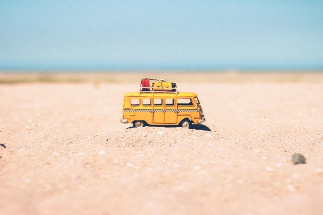 Petite figurine d'un bus de vacances sur la plage
