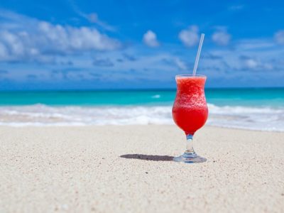 Cocktail de fruits rouges posé sur une plage de sable de la Côte d'Azur.