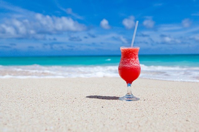 Cocktail de fruits rouges posé sur une plage de sable de la Côte d'Azur.
